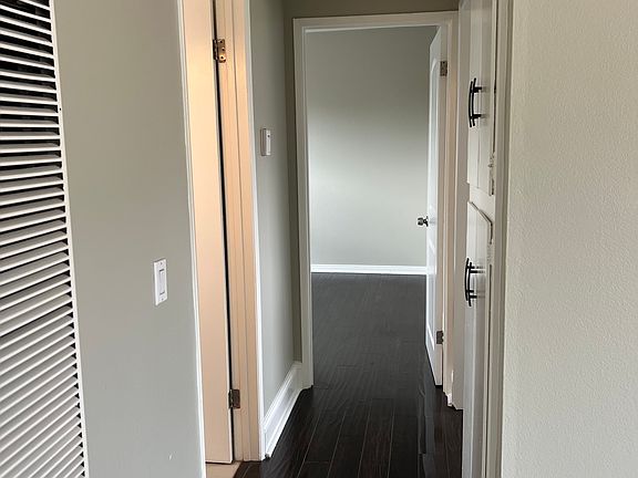 Hallway with linen closet and wall heater.