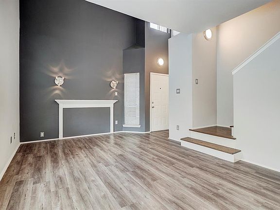 A better view of the same Fire Place wall, showing the front door and front window. The entry area and FP area is 2 stys high to the ceiling. A coat c