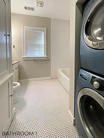 Bathroom has storage cabinets, a full-size washer and dryer, and large antique soaking tub.