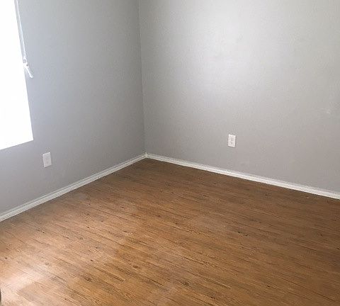 Bedroom with updated flooring and beautiful gray walls that