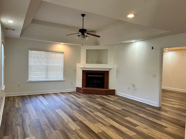 Living Room with tray ceiling, recessed lighting, ceiling fan and fireplace!