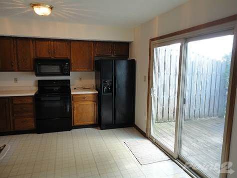 View of the doors off the kitchen leading to back patio and fully fenced backyard
