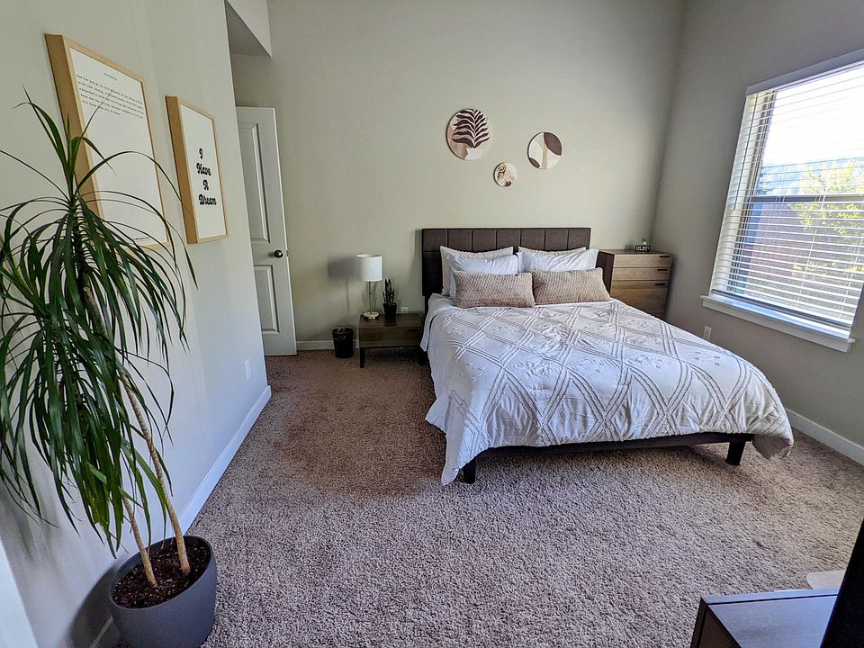 Spacious primary bedrooms with large window and neutral finishes.