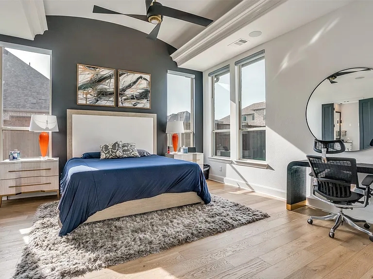 Bedroom with wood-finish flooring, a vaulted ceiling, and a ceiling fan