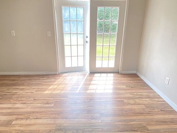 View from living room through dining room to French doors that lead to the fenced in back yard.
