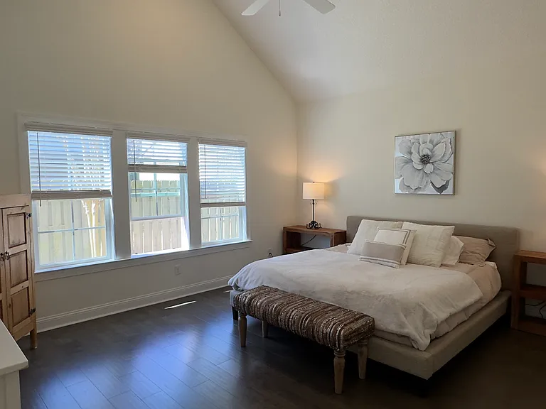 Spacious primary bedroom with neutral furnishings