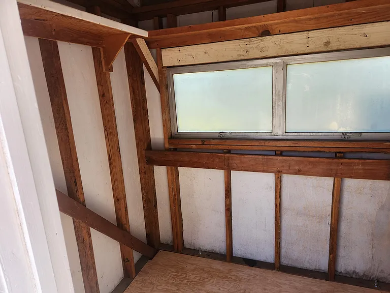 Inside of storage shed. Has windows that open out for fresh air.