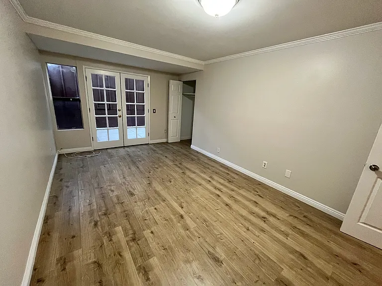 downstairs bedroom with french doors to patio