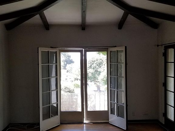 LIVING ROOM W/BEAMED CEILINGS TOWARD BALCONY