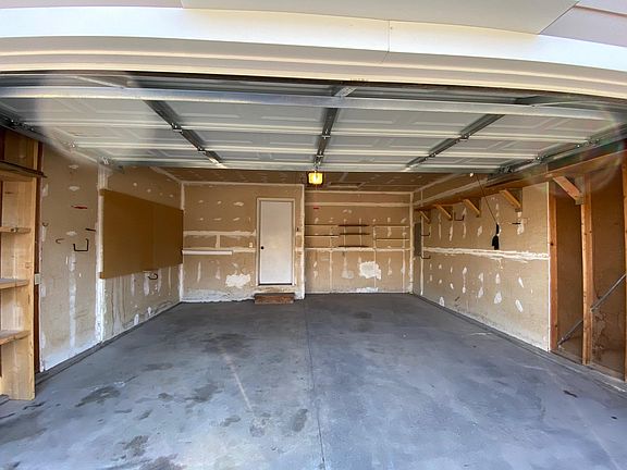 Large 2 car garage with storage shelves. Enters to main level.