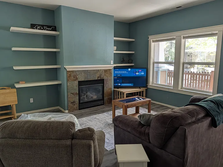 Living room with large windows looking onto the front porch and yard