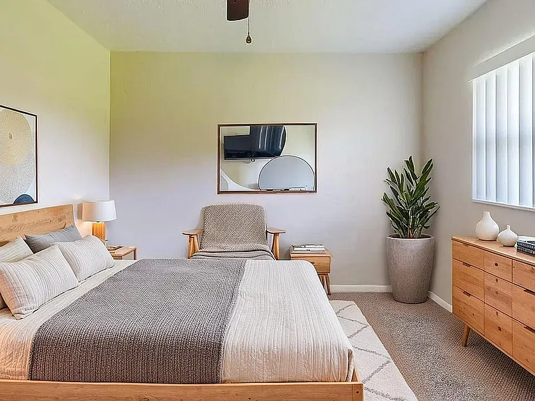 Bright and inviting bedroom featuring a cozy double bed, stylish decor, and ample natural light from large windows.