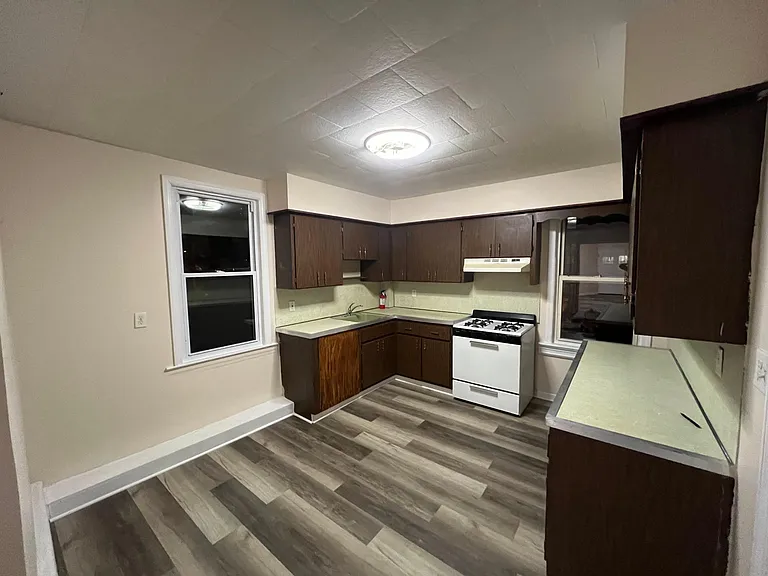 (Kitchen 1/4) Large kitchen w/ stove and rangehood. Large counter space available near the sink area and a separate island.