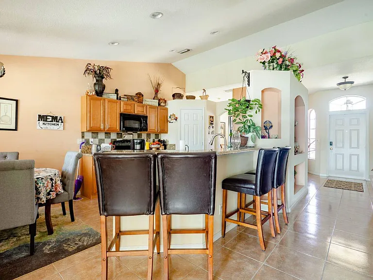 Open-concept kitchen with breakfast bar seating, ample cabinetry, and easy flow to the main living and entry areas.