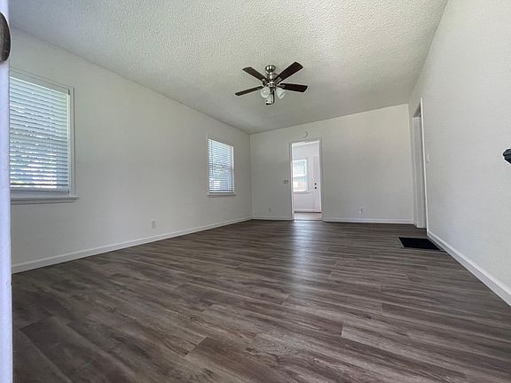 Living room also includes a floor furnace, ceiling fan, new plank flooring