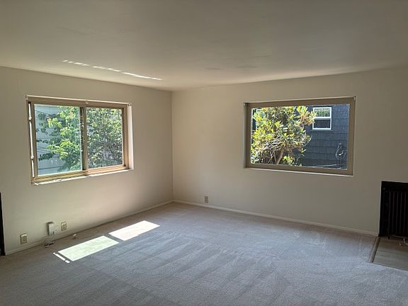 Sunny, roomy living room with new carpeting.