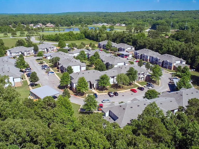 Gaze upon our serene community in Cabot, Arkansas, with abundant parking and carports, framed by the lush embrace of green trees, creating a tranquil atmosphere for your daily life