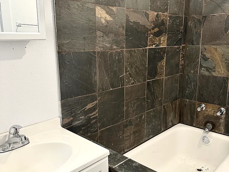 Experience luxury with this elegantly designed bathroom, featuring bold stone tiles and a sleek vanity. Experience luxury with this elegantly designed bathroom, featuring bold stone tiles and a sleek vanity.