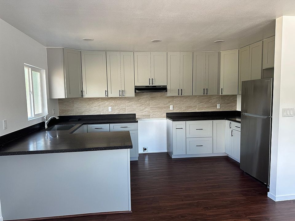 Brand new kitchen cabinets are grey (lighting changed color). Solid wood cabinets with soft-close hardware installed. New refrigerator. New stove will arrive before move-in date.