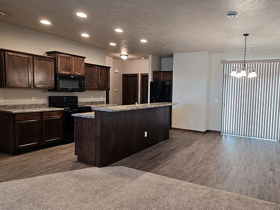 View from Living Room of Kitchen and Dining Area with access to Covered Patio and Back Yard.