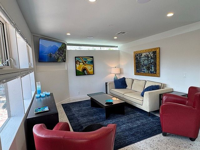 Living area from entry. Recessed flat panel door. Anne Lane painting - "Poolside at the El Conquistador" hangs above the B&B Italia 8'' Maxalto sofa. Edward Wormley coffee table with mosaic extensions, and side tables.