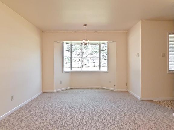 Bay window in formal living has view of gorgeous fountain across the street from this property. Water views in front and back of home!