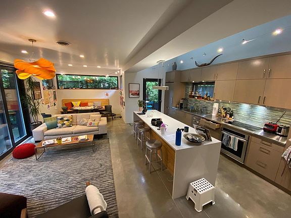 Open Kitchen Living Dining. Beyond, through the kitchen is a small patio for outdoor dining, and a BBQ.