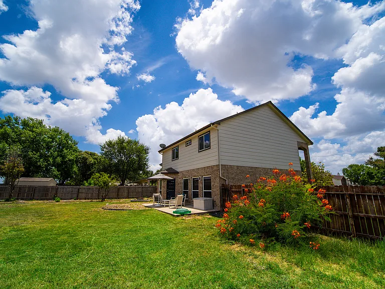 An incredible, expansive backyard entirely enclosed by a privacy fence. With endless green space, mature trees, and room for outdoor play structures, it's a paradise for pets, children, and outdoor gatherings.