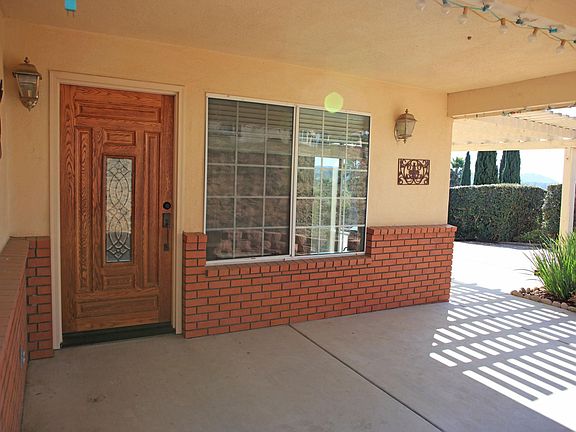 The entry door is under a covered patio.