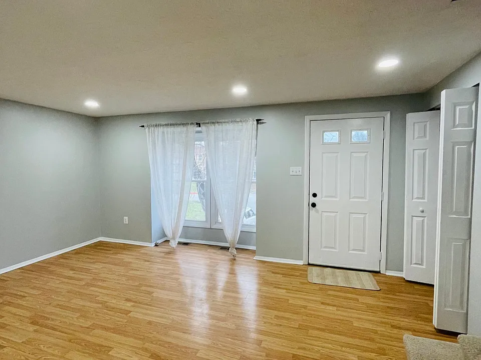 Living room with 2 large windows for natural lighting and modern recessed lighting.