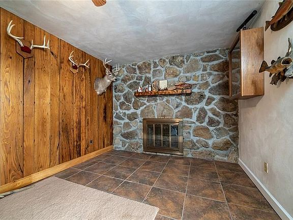 FAMILY ROOM WITH WORMY CHESTNUT PANELING,  WOODBURNING FIREPLACE AND TILE FLOOR.