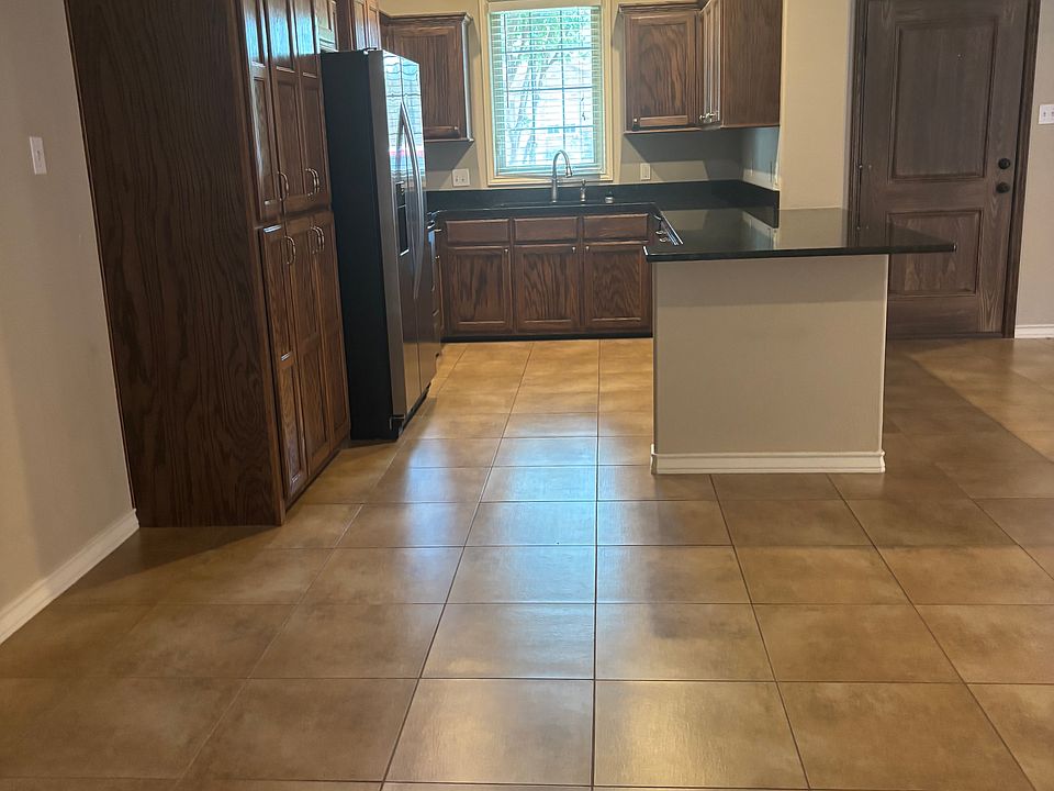 Front kitchen with eat on bar area and all appliances including double door refrigerator