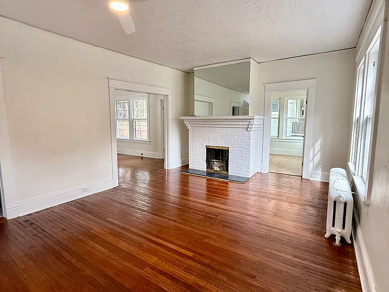 Living room with beautiful original hardwood floors and fireplace