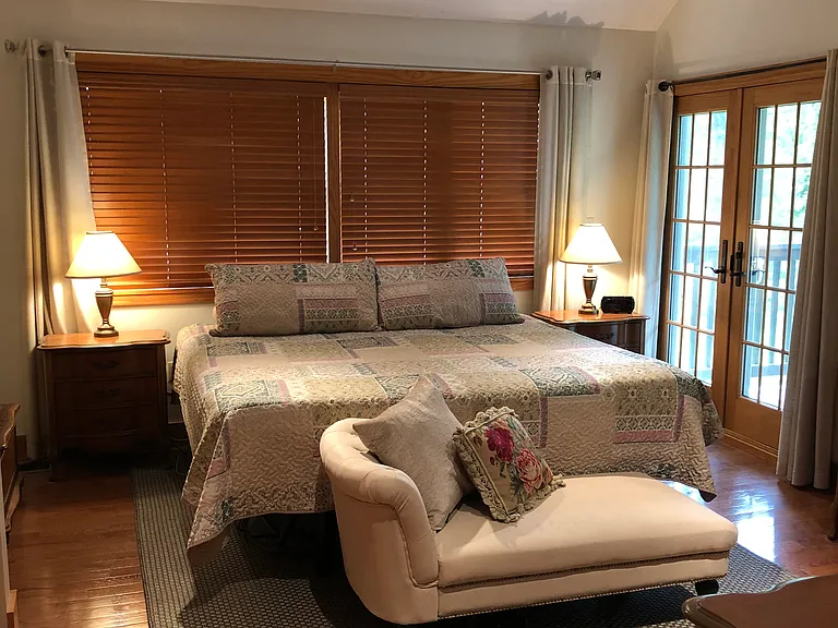 Primary bedroom, cathedral ceiling, two skylights, hardwood floors, balcony off to right