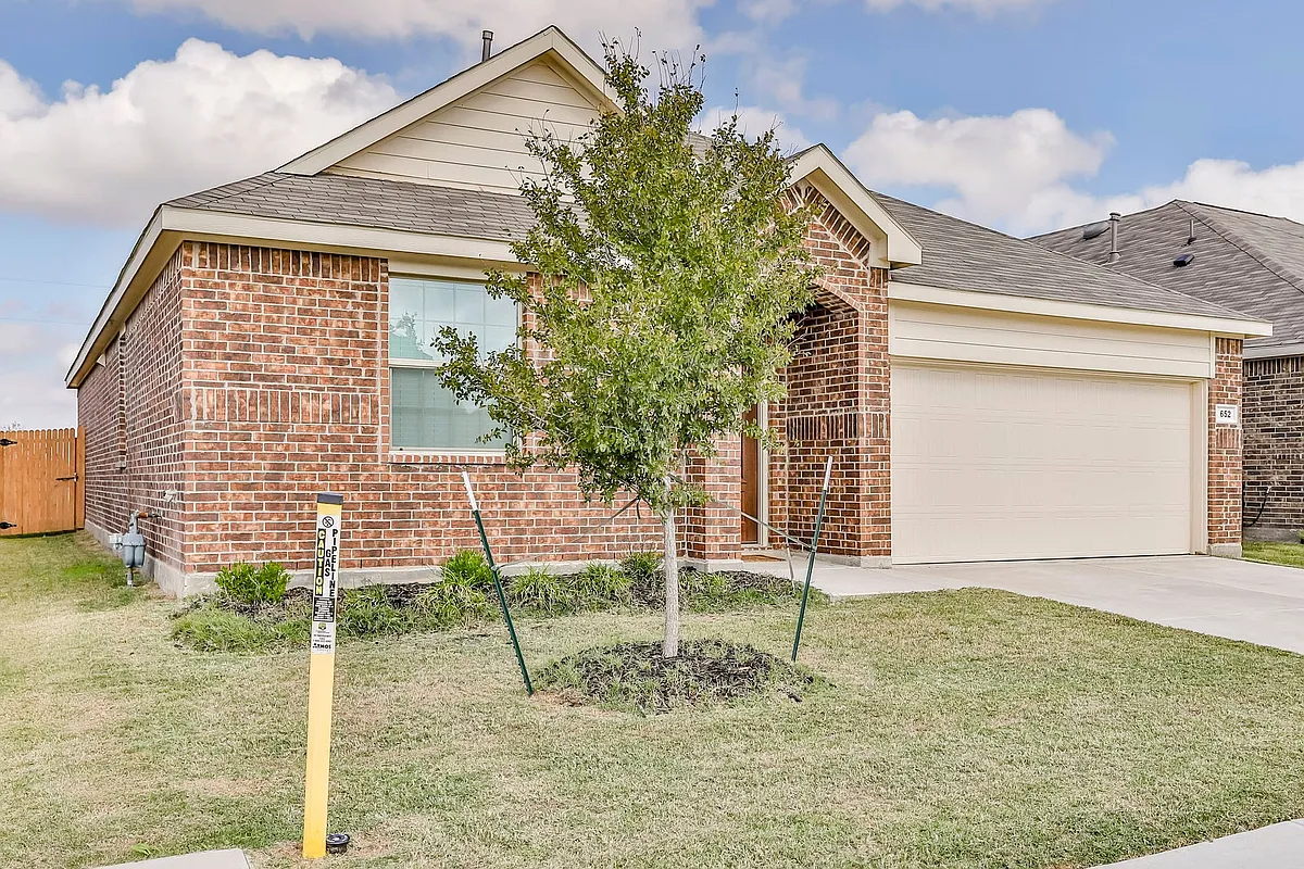 View of front of house featuring a garage and a front lawn - 652 Ridgeback Trl