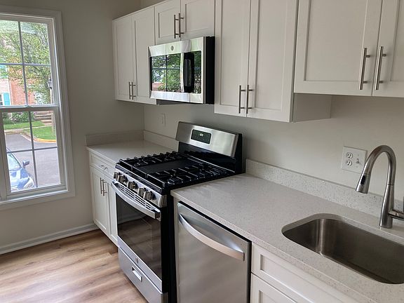 New kitchen cabinets, gas stove, dishwasher, quartz countertops, microwave and refrigerator.