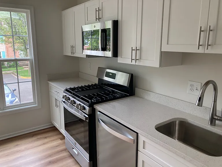 New kitchen cabinets, gas stove, dishwasher, quartz countertops, microwave and refrigerator.