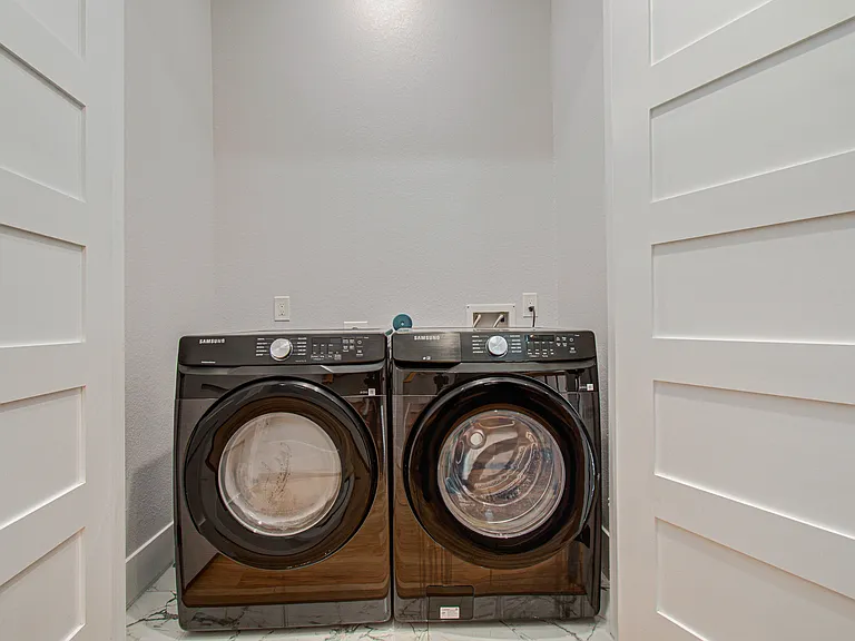 Dedicated laundry room with full-size washer and dryer, providing the convenience of in-home laundry during short or extended stays.