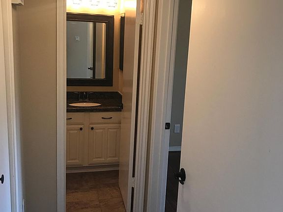 Third view of bathroom from hallway, bedroom on right and walk-in closet on left.