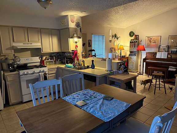 Breakfast area (with ceiling fan) looking into kitchen and living room.