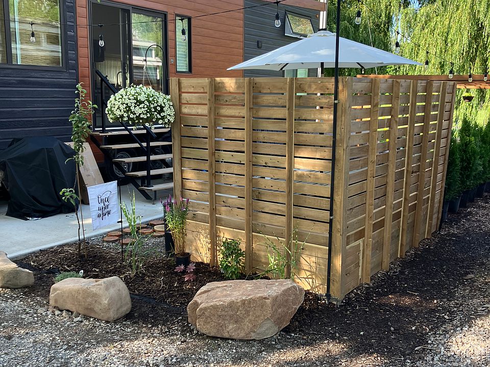 Welcome to our tiny house! Gravel driveway to entrance with beautiful willow trees at the back of the unit