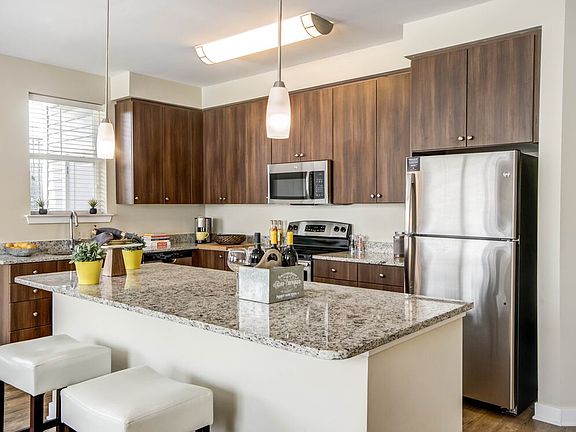 Two bedroom open concept kitchen with granite countertops, stainless-steel appliances, kitchen island and hard surface flooring