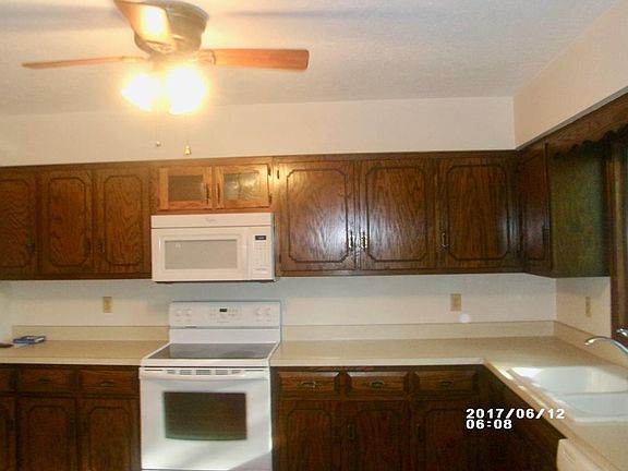 Kitchen Flat Top Range, Microwave, Lighted Ceiling fan, Abundance of Oak Cabinetry. Newer crank out window over sink for easy opening.