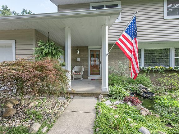 The brick and vinyl exterior are enhanced by beautiful landscaping and wood shutters.