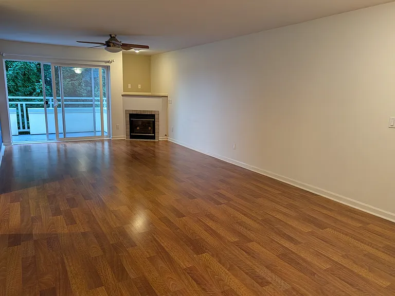 Enter into open floorplan living room w/ gas fireplace. Wide sliding glass door offers views and balcony access.