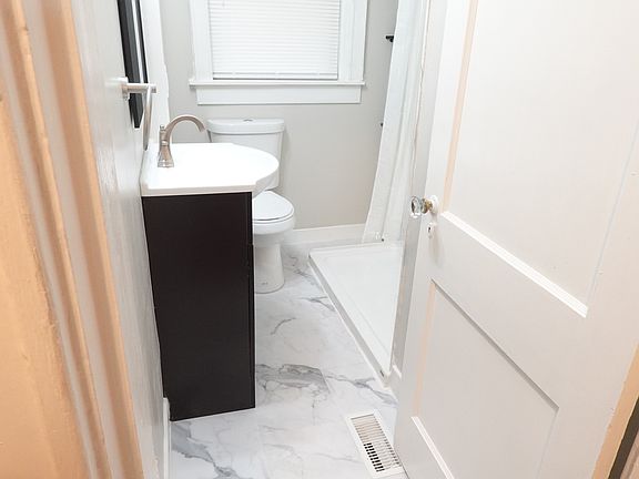 Brand new updated bathroom, with vanity storage as well as corner storage near beautiful new flexstone glacier marble shower w/ marble luxury vinyl floors.