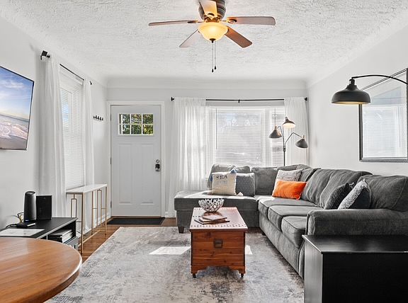 Family room with large sectional seating & ceiling fan
