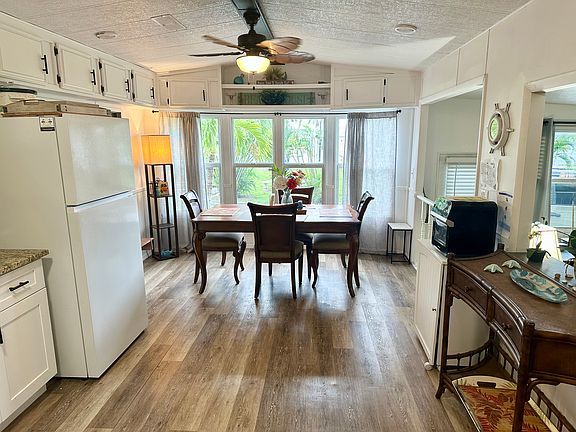 Bright and sunny dining room with gorgeous hard wood table and comfortable chairs