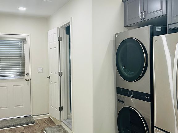 Shown here is the side hallway entrance, and doorway to bathroom, along with a brand new in-unit washer and dryer.