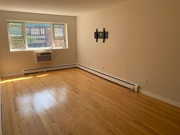 Large living room with wall TV bracket. Newer A/C unit.